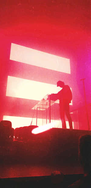 音樂家在紅色舞台上彈奏鍵盤，身後有發光的水平條紋。 — Pixel 4 壁紙