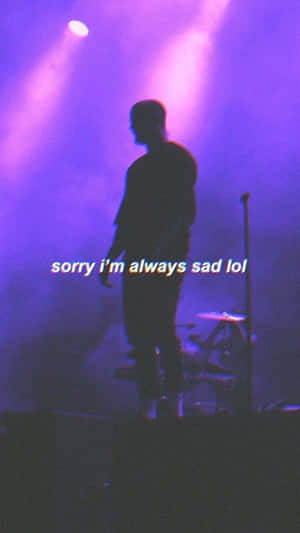 剪影音樂家在紫色燈光下的舞台上，帶有文字疊加顯示 sorry i'm always sad lol。 — 可愛的悲傷 壁紙
