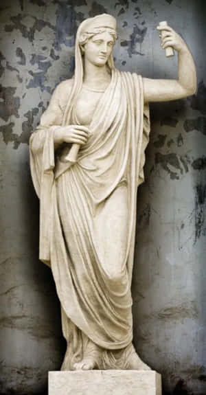 古典大理石雕像，一位披著布料、手持卷軸的女性，背景為風化牆面。 — Pixel Fold 壁紙