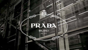 Prada Milano標誌在玻璃店面，帶有鏈條設計和室內燈光反射。 — Prada 壁紙