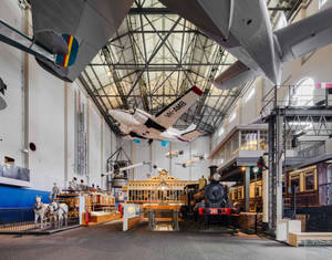 博物館展覽，玻璃天花板下懸掛飛機、火車和復古車輛 — 太空船 壁紙