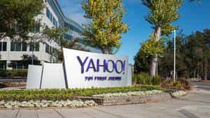 位於701 First Avenue的Yahoo企業標誌，周圍環繞著樹木和花卉。 — 雅虎 壁紙