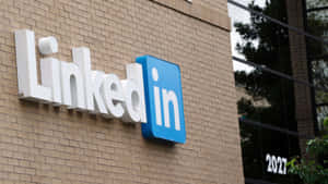 帶玻璃窗的磚砌辦公樓上的LinkedIn標誌。 — 領英 壁紙