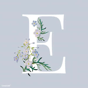 字母E以藍白色花朵和綠色葉子裝飾，灰色背景。 — 艾菲爾鐵塔 壁紙