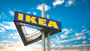 大型 IKEA 標誌在日落時分映襯著藍天白雲。 — 夕陽天空 壁紙