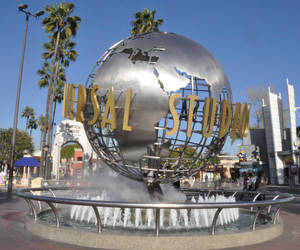 Universal Studios 地球儀噴泉，背景有棕櫚樹和清澈的藍天。 — 環球影城 壁紙