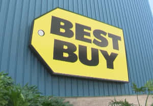 藍色金屬建築上的Best Buy商店標牌，下方有綠色植物 — 最佳購買 壁紙
