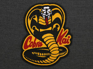 Cobra Kai 徽章，深灰色布料上有刺繡蛇。 — 眼鏡蛇道館 壁紙