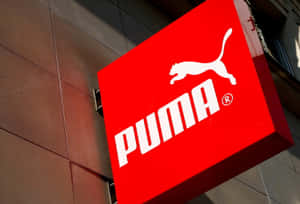 建築物外部帶有白色標誌的紅色Puma品牌標誌牌。 — 噗卡 壁紙
