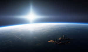 太空站繞地球運行，太陽在彎曲的地平線後方照耀 — 丘陵景觀 壁紙