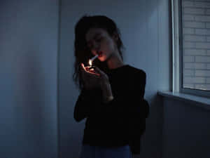 女人在昏暗的藍光下，在室內窗邊點燃香煙。 — 抽菸 壁紙