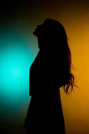 一個女人在青綠色和橙色漸變背景下的剪影。 — 暗黑少女風 壁紙