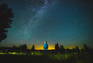 人站在田野中，星空下可見銀河 — 星星 壁紙