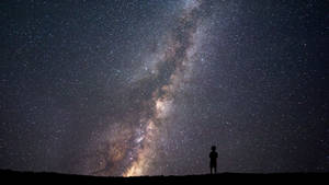 一個人獨自站在星空下，銀河系清晰可見。 — 星星 壁紙