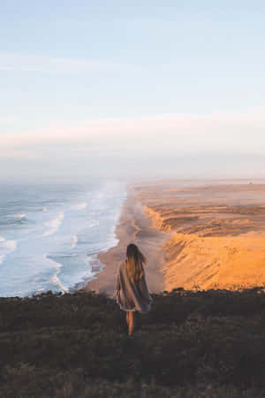 女人站在懸崖邊觀看日出時的海洋 — 海景 壁紙