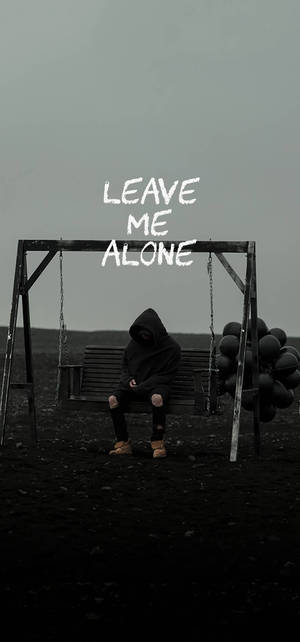 穿連帽衫的人坐在鞦韆長椅上，帶有 leave me alone 文字 — 孤獨 壁紙
