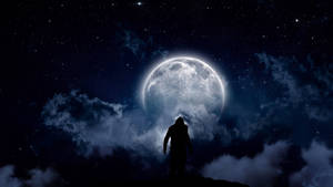 懸崖上的人影剪影，夜間透過雲層凝視大月亮。 — 高畫質月亮 壁紙