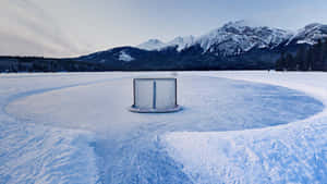 冰凍湖面上的曲棍球網，背景是白雪覆蓋的山脈 — 冰 壁紙