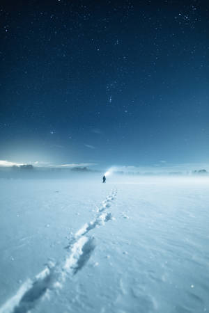一個人在星空下的雪地中獨自行走。 — 史詩 壁紙