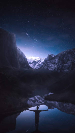 人在湖中張開雙臂，星空下，有雪山倒影 — 湖泊 壁紙