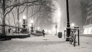 夜晚人行道上撐傘在雪中行走的人 — 酷寒冬季 壁紙