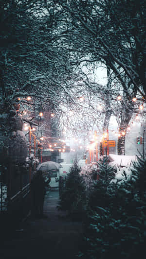 夜晚在燈串下撐傘在雪中行走的人 — 冬季美學 壁紙