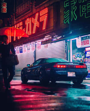 撐紅傘的人走過停在霓虹燈下、雨夜街頭的跑車。 — 賽車 壁紙