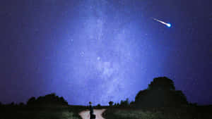 一個人站在星空下的路上，有流星 — 藍天 壁紙