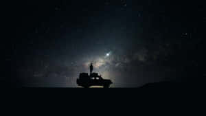 星空下車輛上的人影剪影與銀河 — 星星 壁紙