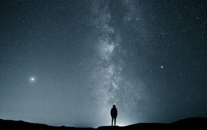 一個人獨自站在星空下，銀河清晰可見。 — 獨自一人 壁紙