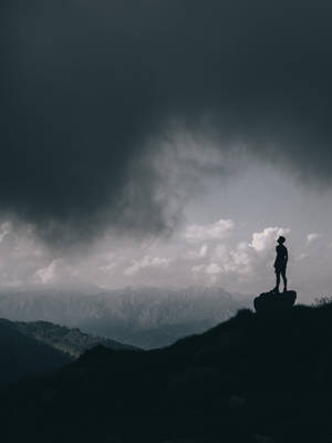 人在暴風雨天空下的山頂上站立。 — 山脈 壁紙