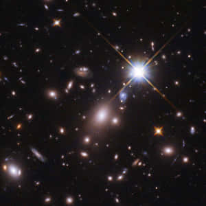深空視圖，顯示星系和明亮的星星，帶有鏡頭光暈效果。 — 宇宙 壁紙
