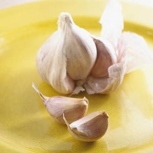 新鮮蒜瓣和蒜頭放在黃色盤子上 — 蔬菜 壁紙