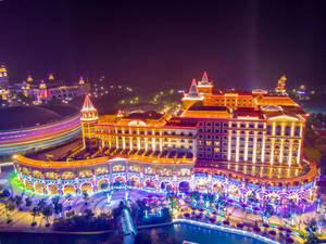 夜間燈火通明的豪華度假村，配有彩色燈光和水景。 — 唐人街 壁紙