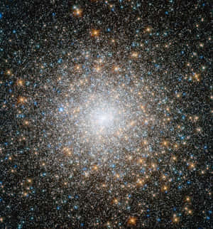 一個密集的星團在深空中明亮地發光，散佈著藍色和橙色的星星。 — 榮耀Magic V 壁紙