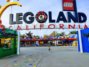 一個小孩在陽光明媚的日子走向節日氣氛的LEGO Land California入口。 — 樂高旋風忍者 壁紙