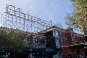 Ghirardelli 標誌在磚建築頂部，伴隨著樹木和藍天 — 加州 壁紙