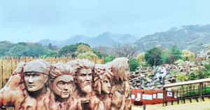 山丘公園中刻有五個戰士面孔的石雕，周圍有綠樹。 — 酷 naruto 壁紙