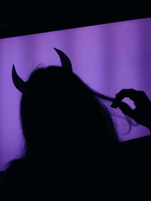 帶有惡魔角的人在紫色光中觸摸頭髮。 — 暗紫色美學 壁紙