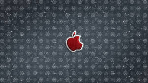 灰色雪花圖案背景上帶有白色縫線的紅色Apple標誌。 — 聖誕節 iPhone 壁紙