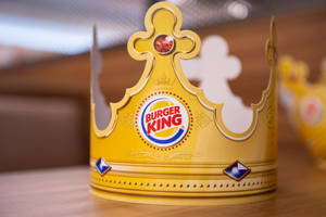 一個帶有紅色寶石的金色Burger King皇冠在木桌上。 — 漢堡王 壁紙