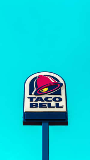 Taco Bell餐廳招牌，在藍綠色背景上有紅色鈴鐺標誌。 — 塔可 壁紙