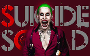 帶有綠色頭髮和紋身的小丑角色在深紅色背景上尖叫，並帶有「Suicide Squad」文字。 — 自殺突擊隊 壁紙