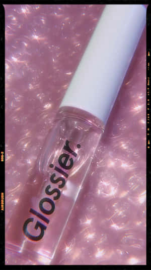 Glossier 唇彩瓶在帶有閃爍效果的粉紅色泡泡背景上。 — 主畫面 壁紙