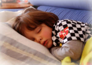 一個年幼的孩子在條紋枕頭上穿著舒適的睡衣熟睡。 — 睡眠 壁紙