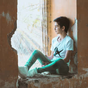 年輕男子坐在廢棄建築的破窗中，沉思地向外眺望。 — 美少年動態圖 壁紙