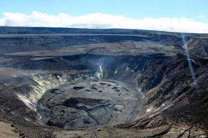藍天下有蒸汽通風口和龜裂土地的火山口。 — 高清 壁紙