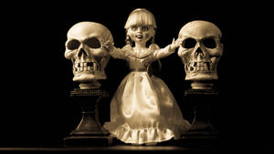 一個 creepy 娃娃，兩側有兩個頭骨在基座上，處於黑暗的攝影棚環境中。 — 芭比美人魚 壁紙
