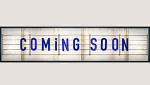 一個復古發光招牌，上面用藍色字母寫著「COMING SOON」。 — 普罗米亚 壁紙