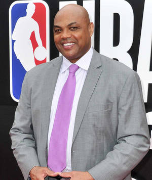 一位身穿灰色西裝和紫色領帶的男士在NBA活動中微笑。 — 科比· Bryant 壁紙
